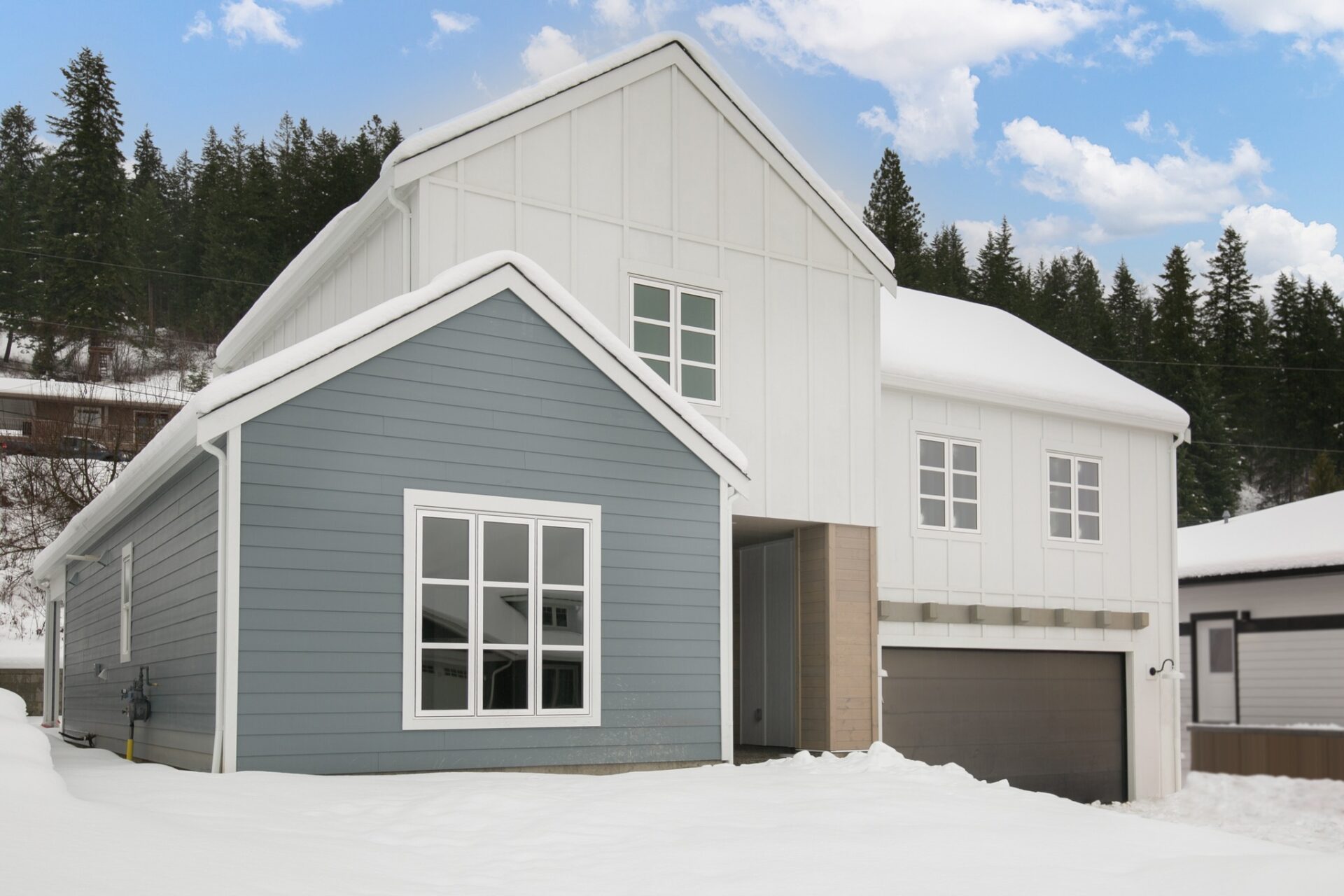 Custom home, winter scene, white and grey siding with wood finishing.