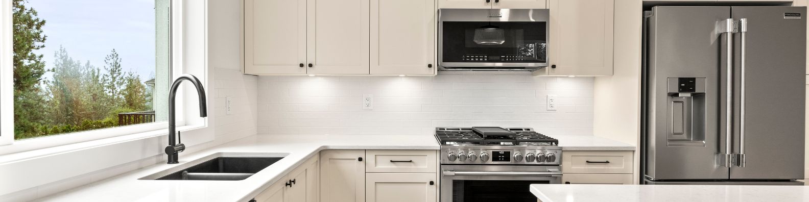 a brand new white kitchen with stainless steel appliances